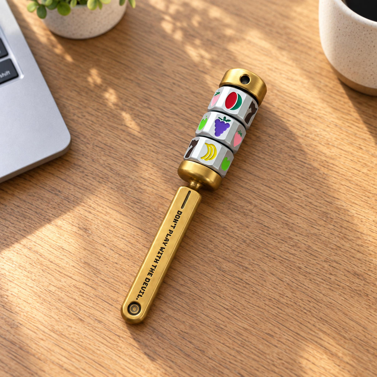 Jackpot spinning reel desk fidget toy resting on leather tabletop beside laptop