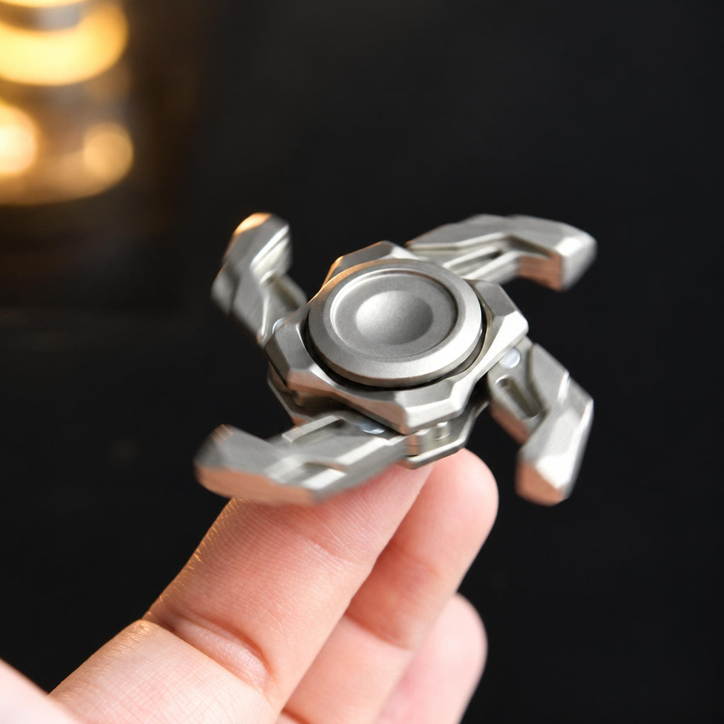 Hand spinning expanded silver metal fidget toy during focused office work