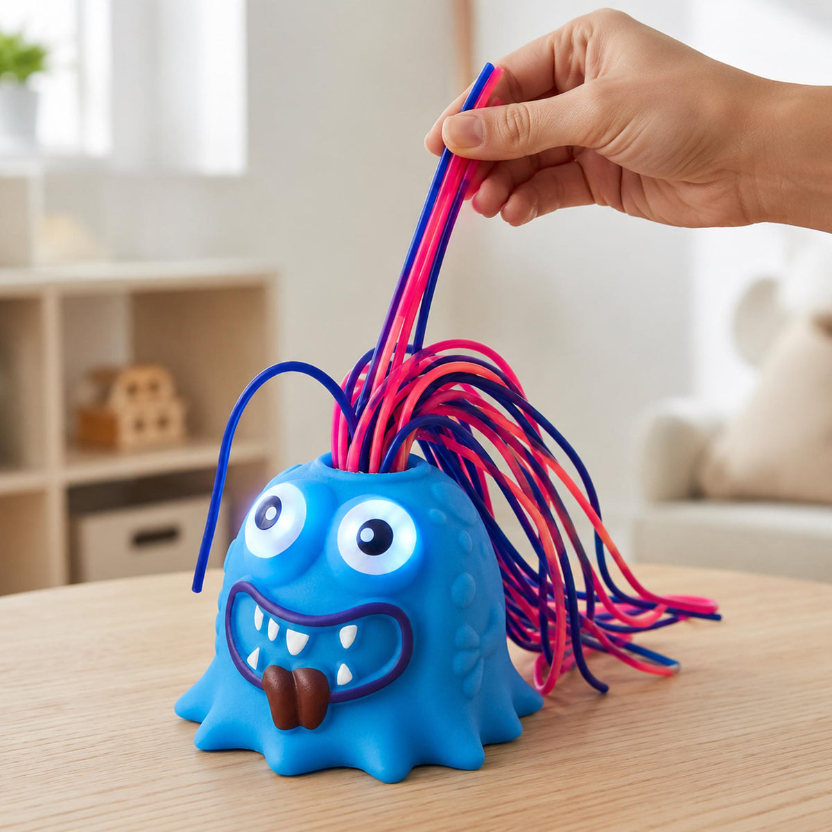 Hand pulling blue screaming monster fidget hair for office stress relief on desk