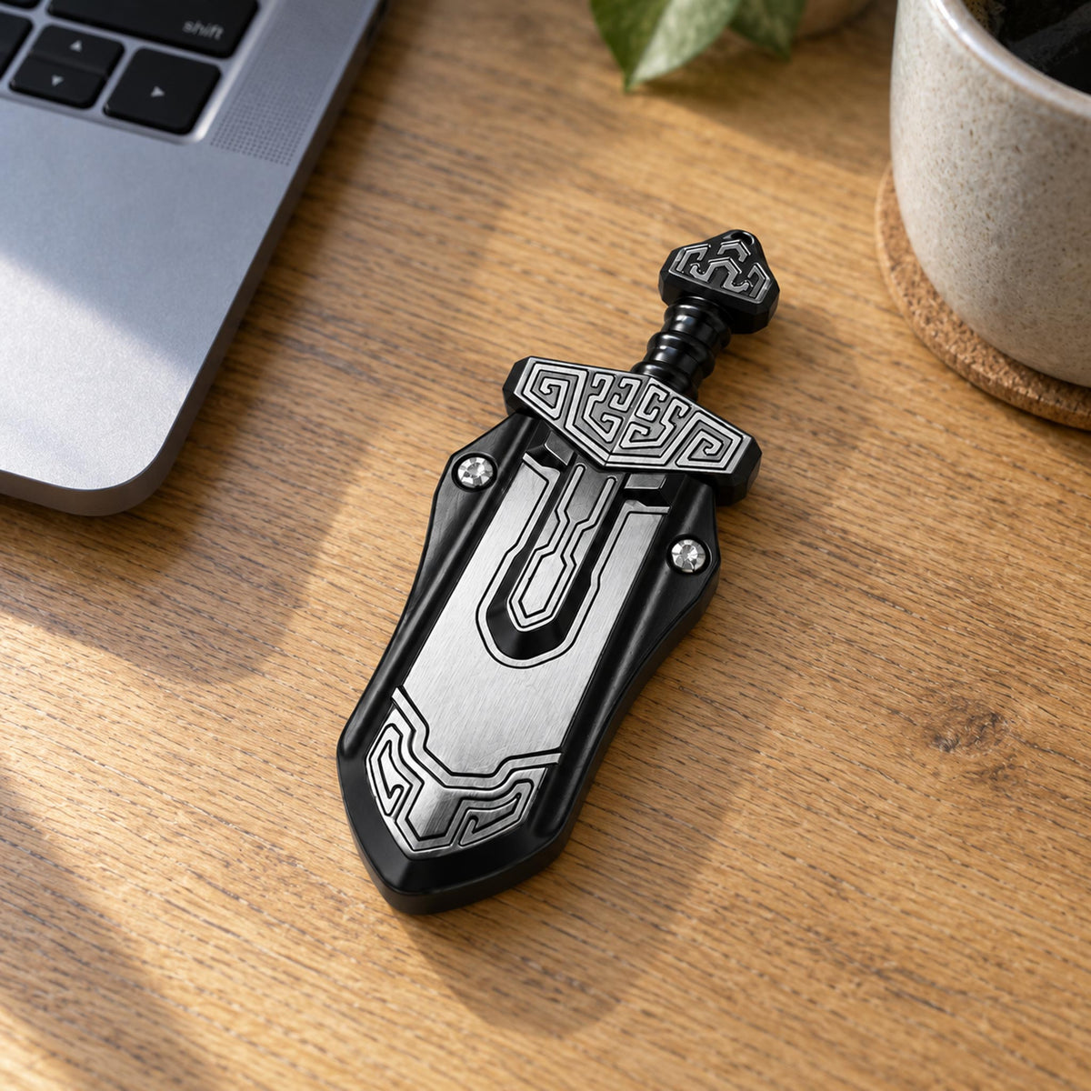 Black metal totem tactile fidget slider placed beside laptop on office desk